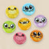 The Bindlewood Shop Chris Ryniak 7-Button Set features seven 1" wide, brightly colored buttons with cute cartoon monster faces, each with big eyes and playful expressions on a light beige backing.