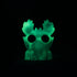The Bindlewood Shop’s Sunshower Moose is a glowing green, glow-in-the-dark resin figure with antler-like protrusions and large circular eye holes, shaped like a stylized animal head and set against a black background.