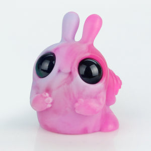 The Neon Hyacinth Helix by Chris Ryniak is a small, pink and purple marbled chubby snail figurine with big shiny black eyes, two short antennae, and tiny front limbs, shown against a plain white background.