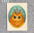 From Bindlewood Shop's Zodiac Prints by Amanda Louise Spayd: a cute cartoon lion with a jeweled crown and starry mane in an oval frame on textured gray, “LEO” in bold white—ideal as a fine art print on archival paper.