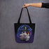A hand holds the Mystical Witchbunny Tote from Bindlewood Shop, featuring a cute witchbunny in a wizard hat among magical symbols—perfect for Amanda Louise Spayd fans.