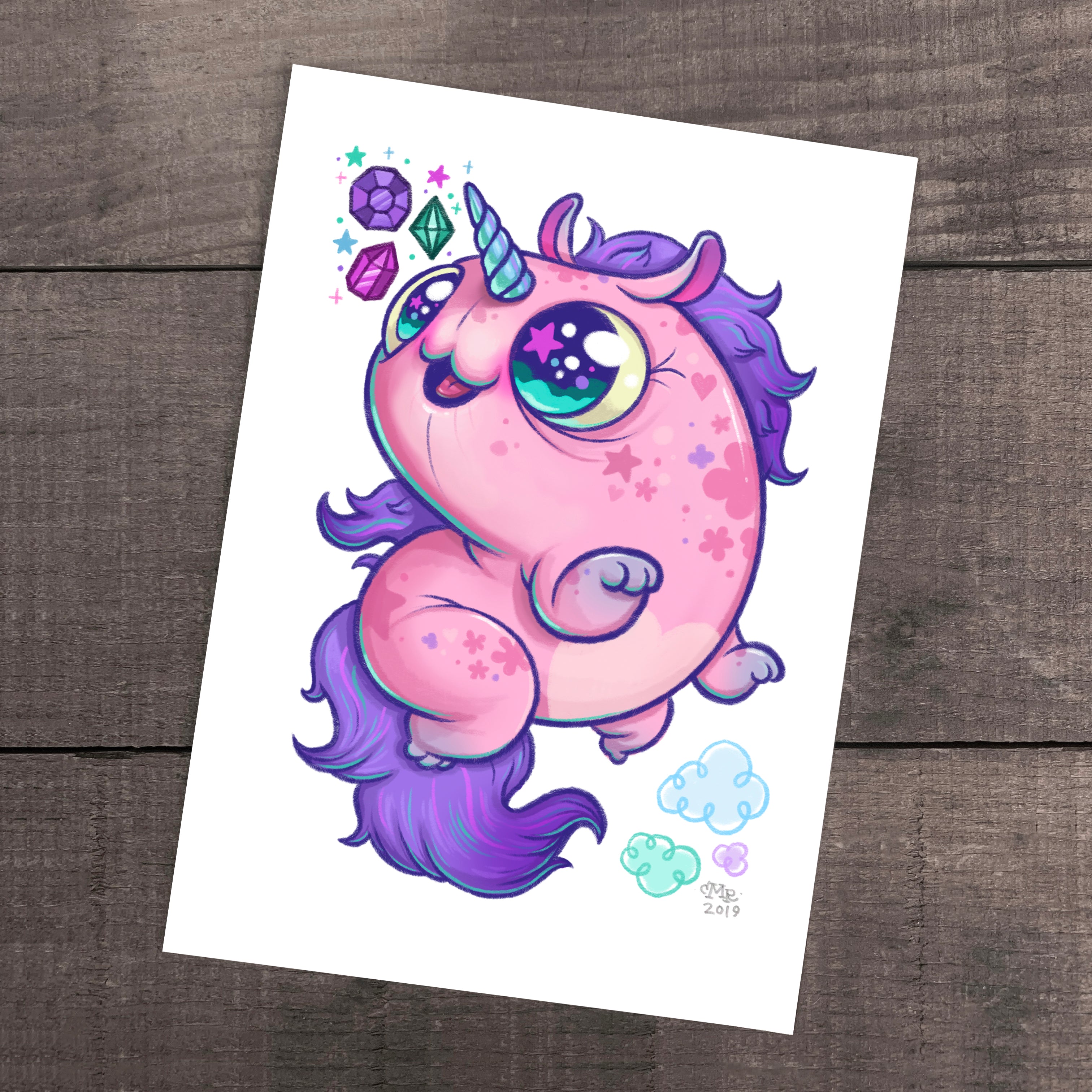 The "Flooficorn" Print by Chris Ryniak features a chubby cartoon unicorn with pink fur and a purple mane, standing on its hind legs among stars, gems, and clouds on archival paper in Ryniak's whimsical style.