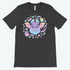 The Bindlewood Shop Pastel Candy Bat Tee is a dark gray, gender-neutral shirt with a cute pastel bat, stars, and two smiling ghosts in purple, green, yellow, and blue.