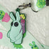 The Bindlewood Shop Succulent Lanyard features cacti and potted plants prints, and comes with a keychain of a green cartoon bunny carrying a basket of colorful succulents.