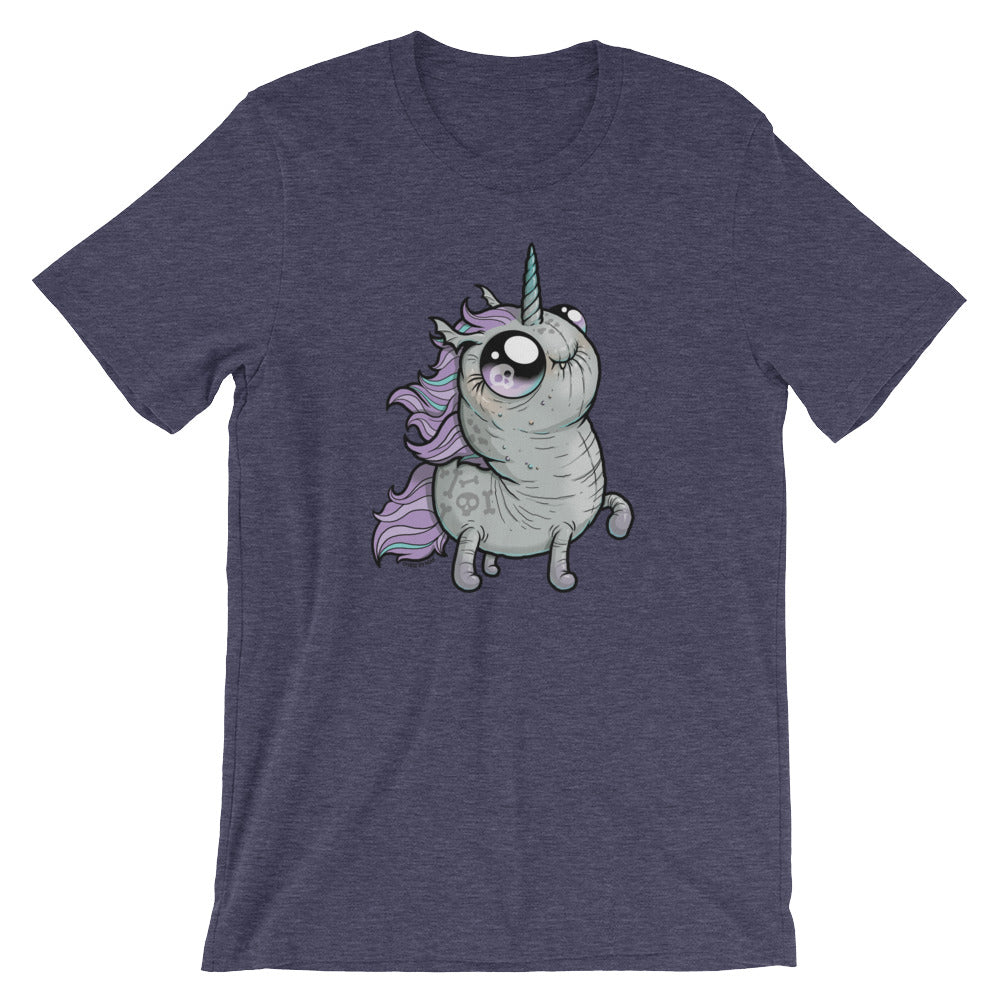 A heather navy blue T-shirt displays a whimsical, cartoon-like unicorn with large, expressive eyes, a rainbow-colored horn, and a purple mane and tail. The high-quality fabric ensures comfort while the gender-neutral fit makes it perfect for anyone. The unicorn stands on its hind legs with an adorable, eager expression. This is the Goth Ponycorn Tee from Bindlewood Shop.