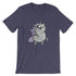 A heather navy blue T-shirt displays a whimsical, cartoon-like unicorn with large, expressive eyes, a rainbow-colored horn, and a purple mane and tail. The high-quality fabric ensures comfort while the gender-neutral fit makes it perfect for anyone. The unicorn stands on its hind legs with an adorable, eager expression. This is the Goth Ponycorn Tee from Bindlewood Shop.