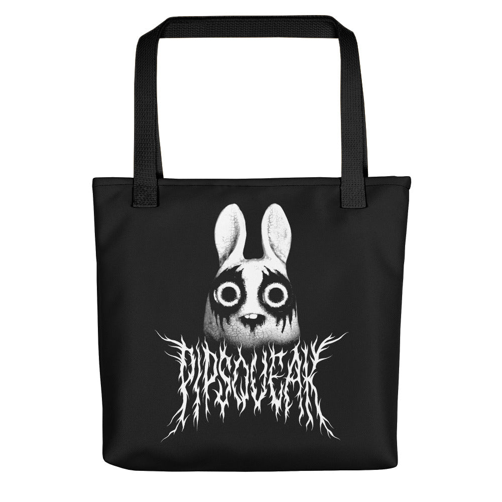 The "Black Metal Pipsqueak Tote" by Bindlewood Shop features a creepy white bunny with dark eyes and a distorted smile on black cotton denim. "Pipsqueak" is written below in a jagged, thorny font, and sturdy black handles enhance its dark aesthetic.