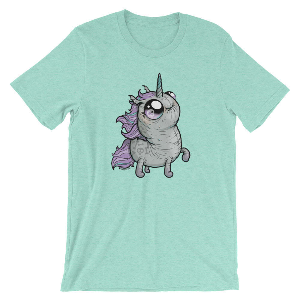 The Goth Ponycorn Tee from Bindlewood Shop is a light green T-shirt featuring a chubby, cute unicorn illustration at the center, made from high-quality fabric. The unicorn has a purple mane, a sparkling horn, and big, expressive eyes, giving it a whimsical and endearing appearance. The shirt boasts short sleeves and a gender-neutral fit with a round neckline.