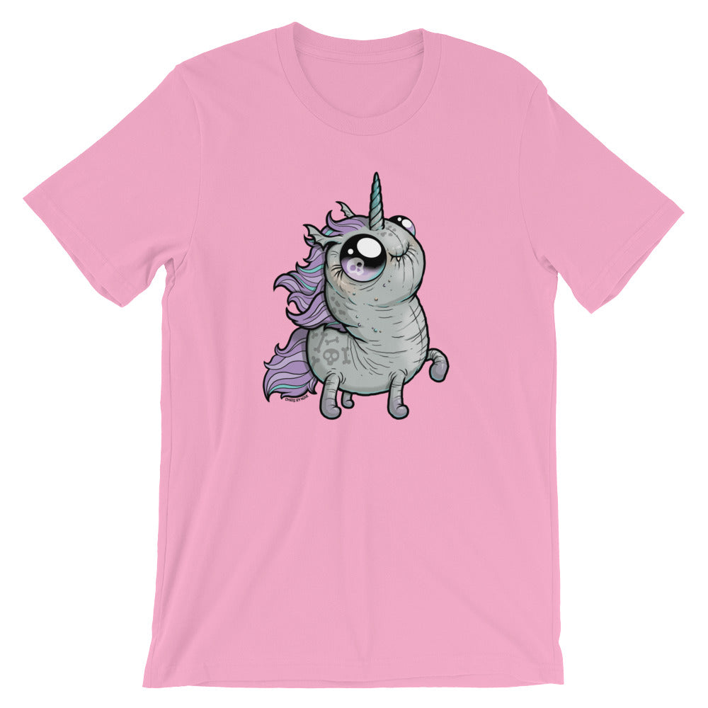 A pink t-shirt featuring a cartoon illustration of a cute, wide-eyed unicorn with a chubby body, small legs, and a purple mane and tail. The Goth Ponycorn Tee from Bindlewood Shop is made from high-quality fabric and has a gender-neutral fit. The unicorn is looking upwards and has a whimsical, endearing expression.