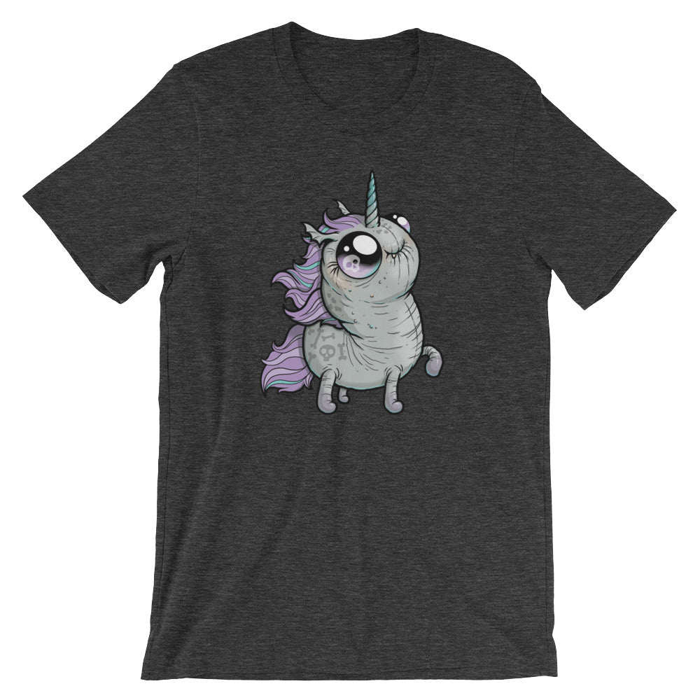 A dark gray T-shirt features a cute, cartoon-style illustration of a small, chubby unicorn with large, shiny eyes, a turquoise horn, and a purple mane and tail. The unicorn appears to be happily prancing. This Goth Ponycorn Tee from Bindlewood Shop boasts high-quality fabric and a comfortable gender-neutral fit.