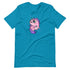 The Flooficorn Tee from Bindlewood Shop is a cozy, lightweight blue shirt with a pink unicorn (inspired by Chris Ryniak's Flooficorn) featuring sparkling eyes, a purple mane and tail, and star accents—a gender-neutral design.
