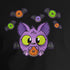 A person wearing a Bindlewood Shop Donut Bat Tee made from soft and lightweight combed and ring-spun cotton, featuring a colorful graphic of a cartoonish purple cat with big green eyes, surrounded by various candies. The individual is standing against a plain white background, with their hands relaxed by their sides.