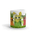 Introducing the Farm Market Dust Bunnies Mug by Bindlewood Shop: a microwave and dishwasher safe ceramic mug adorned with charming, anthropomorphic vegetable characters. Meet an orange carrot, a yellow corn with a bow, and a red radish—all featuring big eyes and cheerful smiles. The background at the bottom is decorated with green leaves and grassy details for an extra touch of whimsy.