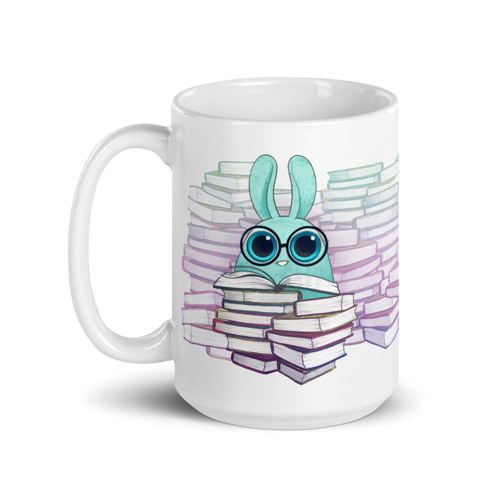The So Many Books Mug by Bindlewood Shop features a wide-eyed rabbit wearing glasses, surrounded by stacks of colorful books against a backdrop of pastel hues. This ceramic mug is not only charming but also functional, being both microwave and dishwasher safe for convenient use and cleaning.